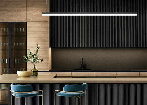 Low profile linear LED light hanging in a dark modern kitchen