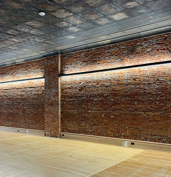 linear LED lights mounted to a brick wall