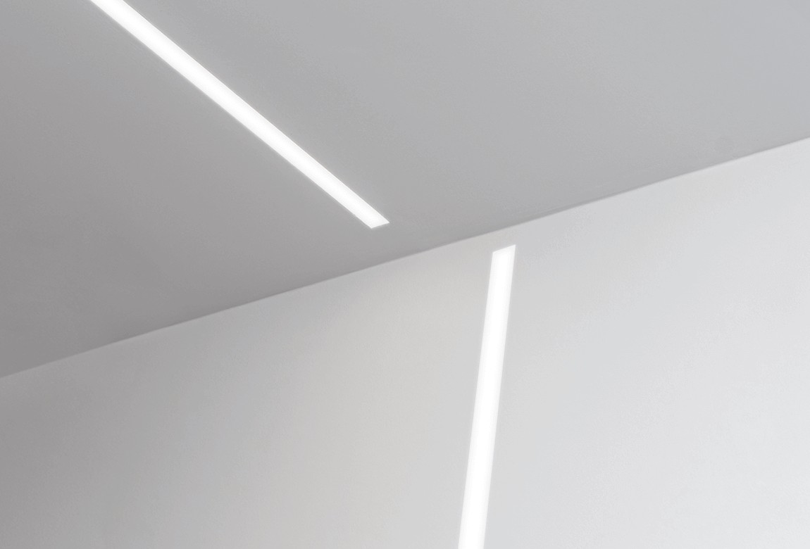 room with recessed linear light on ceiling and wall