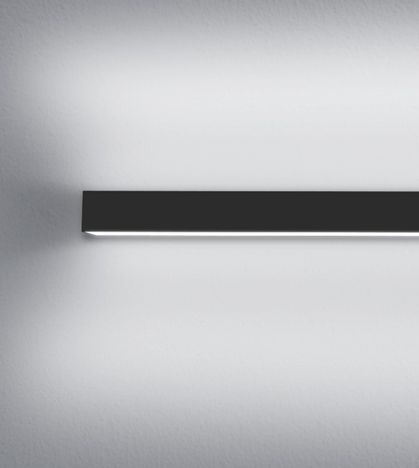 black linear light fixture mounted to a wall with light coming from top and bottom
